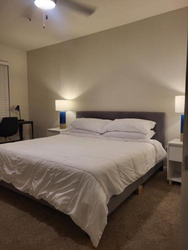 a bedroom with a large bed with white sheets and pillows at Downtown Dallas 2bd free parking in Dallas