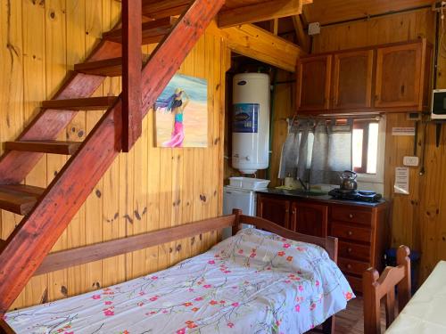 um quarto com uma cama num chalé de madeira em Cabañas La Soñada del Río em Victoria