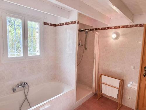 a bathroom with a tub and a shower with a window at Charming Villa in Villes-sur-Auzon with Swimming Pool in Villes-sur-Auzon