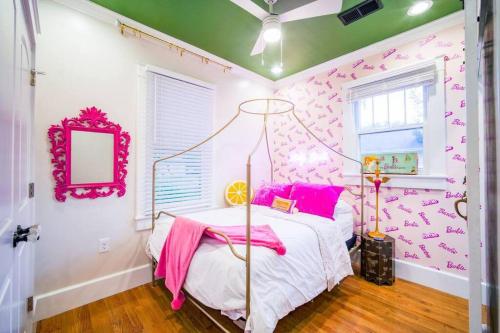 a pink and white bedroom with a bed and a mirror at The Cullman Haus-Steps frm Cullman High-CHORE FREE in Cullman