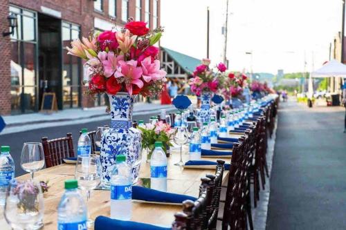 a long table with flowers in a blue and white vase at The Cullman Haus-Steps frm Cullman High-CHORE FREE in Cullman