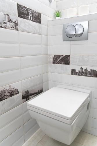 a white toilet in a bathroom with black and white tiles at Balkan dream **** in Belgrade