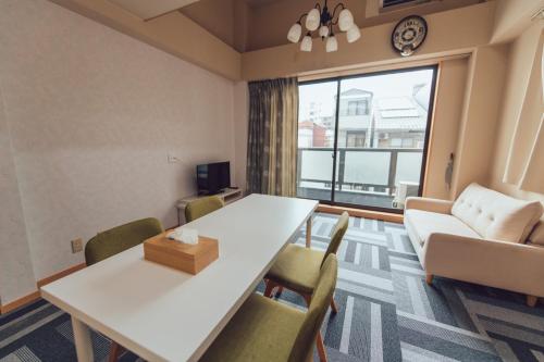 a living room with a white table and chairs at 唐風家 大国町 近邻地铁 in Osaka