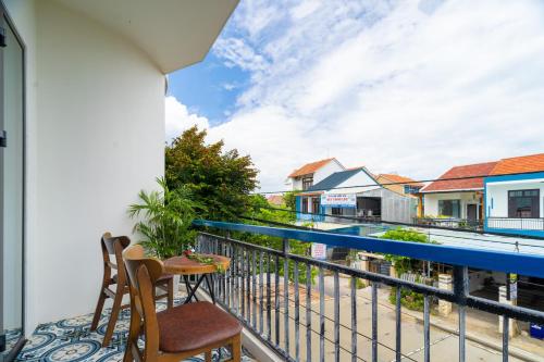 a balcony with chairs and a view of a street at 5 Coconut Villa in Hoi An