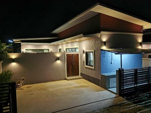 a house with lights on the side of it at night at DPool Villa in Sattahip