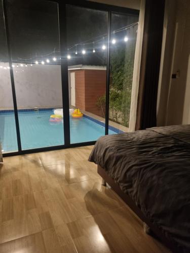 a bedroom with a view of a swimming pool at DPool Villa in Sattahip