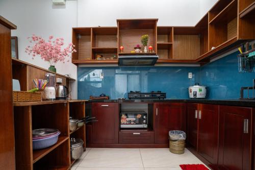 a kitchen with brown cabinets and a blue wall at 5 Coconut Villa in Hoi An