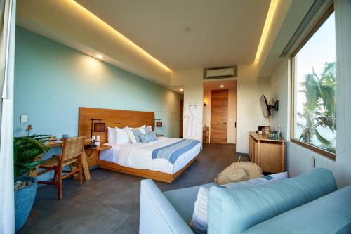 a bedroom with a bed and a table and a couch at Hotel Basalto in Punta Mita
