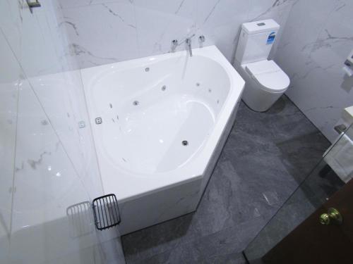 biała łazienka z wanną i toaletą w obiekcie St Georges Motor Inn w Melbourne