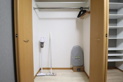 Cette chambre comprend un placard avec un ventilateur et un tapis de course. dans l'établissement Osaka Arita Stay Ⅰ, à Osaka
