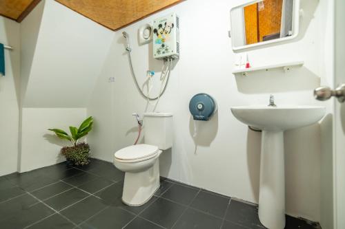 a bathroom with a toilet and a sink at ภูตะวัน-บ้านท่าจัน ม่อนแจ่ม in Mon Jam