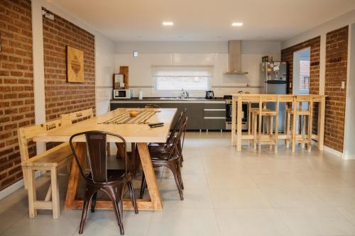 a kitchen with a wooden table and chairs at La Casita Boutique in Chos Malal