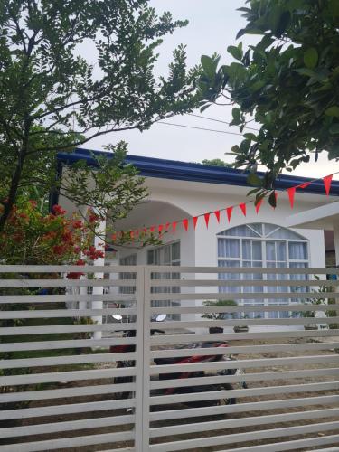 een wit huis met een hek ervoor bij Palapag White House, your holiday home in Palapag