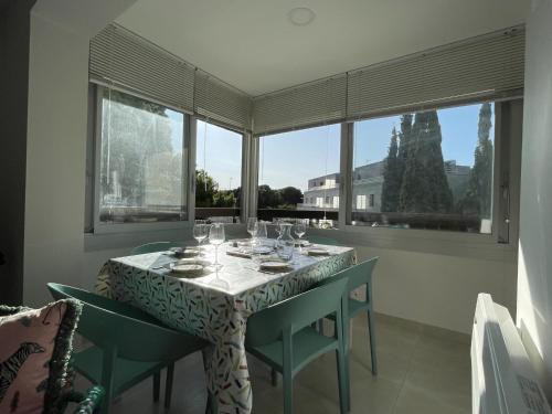 une salle à manger avec une table, des chaises et des fenêtres dans l'établissement Appartement 2 étoiles à Sète : 3 pièces près de la plage avec parking et équipements modernes - FR-1-338-511, à Sète