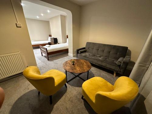 a living room with yellow chairs and a couch at Inn By The Sea, Portsmouth - EN SUITE Rooms with or without Sea View in Portsmouth