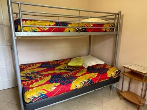 a bunk bed with a colorful comforter on it at VILLA NATURE in Baie-Mahault