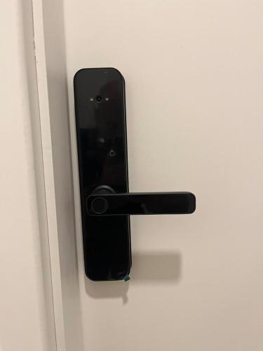 a black door handle on a white door at GREEN ONE - Apto novo, moderno, varanda, poucos passos da estação Luz in Sao Paulo