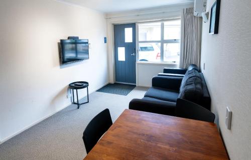 a living room with a couch and a table at Ripple Rotorua in Rotorua