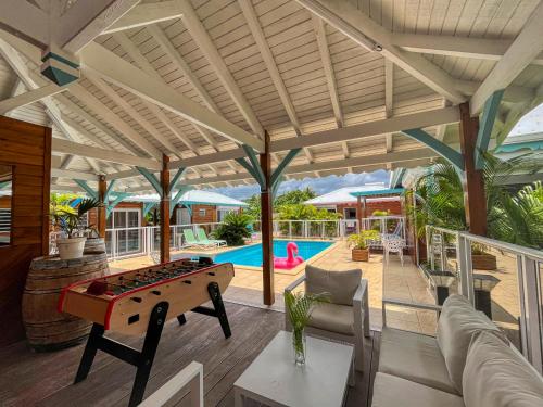 an outdoor living room with a pool table at Gites Fleurs d'abeilles in Anse-Bertrand