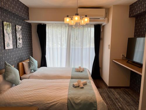 a bedroom with two beds with teddy bears on it at @RLiS_house大阪ドームシティ in Osaka