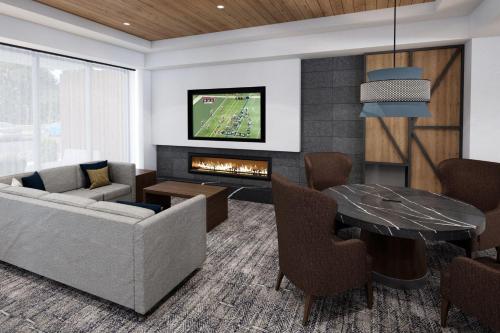 a living room with a couch and a fireplace at STAYBRIDGE SUITES Des Moines North - Ankeny by IHG in Ankeny