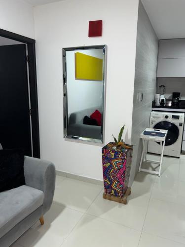 sala de estar con espejo en la pared en Apartaestudio Barranquilla Recreo, primer piso, en Barranquilla