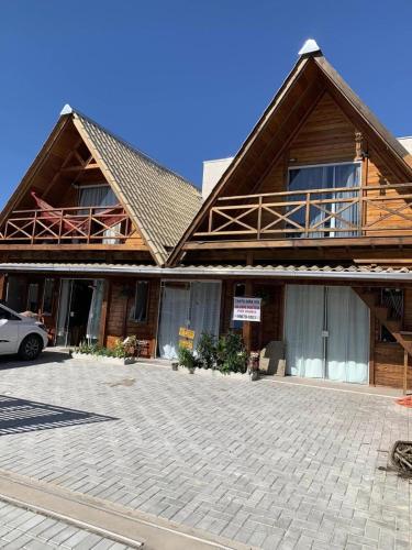a house with a car parked in front of it at Canto Gira Sol - Suíte Flor in Penha