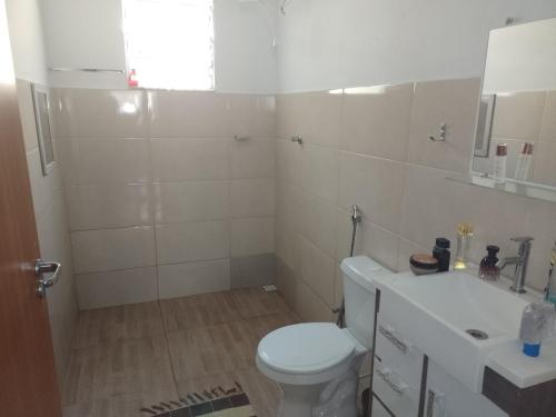 La salle de bains blanche est pourvue de toilettes et d'un lavabo. dans l'établissement Casa vila da fumaça, à Resende