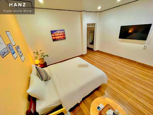 Schlafzimmer mit einem weißen Bett und einem TV in der Unterkunft HANZ AND Sunset Beach Resort in Phu Quoc