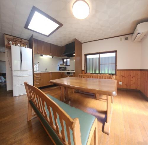 a kitchen with a dining room table and a refrigerator at GUESTHOUSE YANAGIYA in Nakatsugawa