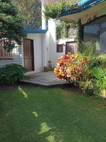 a front yard of a house with a door and flowers at Casa Atlixco de las Flores in Atlixco