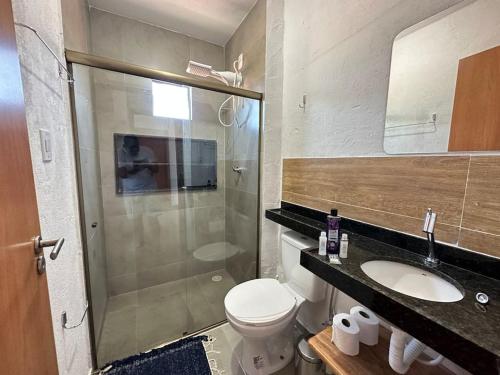 a bathroom with a shower and a toilet and a sink at Casa Tapera - Porto de Pedras/AL in Pôrto de Pedras