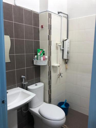 Baño pequeño con aseo y lavamanos en The Hanraz home stay en Kota Tinggi