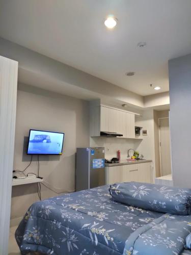 a bedroom with a bed and a flat screen tv at Grand Kamala Lagoon Bekasi Apartement - Type Studio in Pulosirih