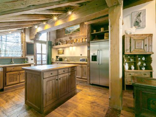 une grande cuisine avec des placards en bois et un réfrigérateur en acier inoxydable dans l'établissement Duplex luxueux avec sauna, cheminée et parking à Val-d'Isère - FR-1-694-334, à Val dʼIsère