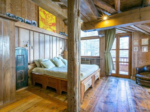 une chambre avec un lit dans une pièce aux murs en bois dans l'établissement Duplex luxueux avec sauna, cheminée et parking à Val-d'Isère - FR-1-694-334, à Val dʼIsère