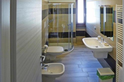 une salle de bain avec deux lavabos et une douche et deux toilettes dans l'établissement Apartment in Tignale with Lake Garda Views, à Tignale