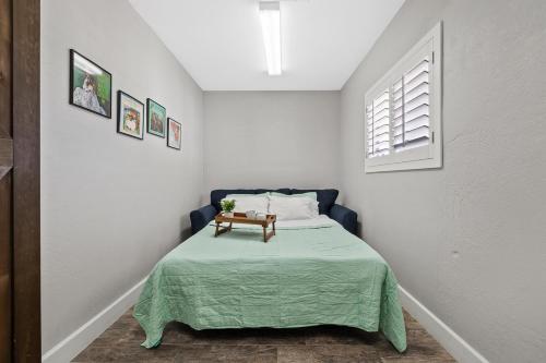 a small bedroom with a bed with a green blanket at Relaxing Old Town Scottsdale desert oasis awaits in Scottsdale