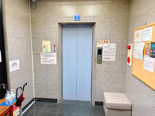eine blaue Tür im Bad mit WC in der Unterkunft エスタールゴヤ in Tomari