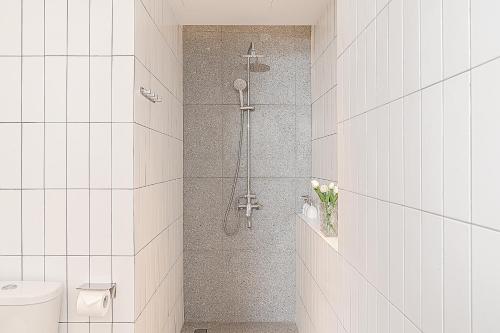 y baño con cabina de ducha y aseo. en M Village Hotel Hai Bà Trưng, en Ho Chi Minh