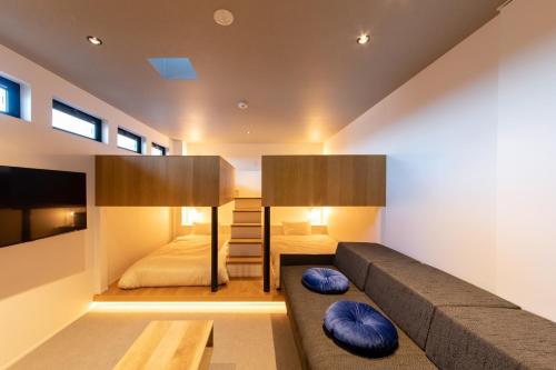 salon z kanapą i łóżkiem w obiekcie セトノウツツ w mieście Suo Oshima