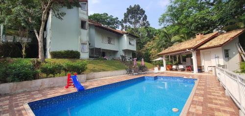 - une piscine en face d'une maison dans l'établissement Casarão perto SP e Rodeio Cajamar - Piscina, Hidro e Lareira com Brinquedos em condomínio de Luxo, à Cajamar