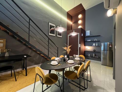 a dining room with a table and chairs and a staircase at Arte Cheras Designer Suite by Moka @ Cheras in Kuala Lumpur
