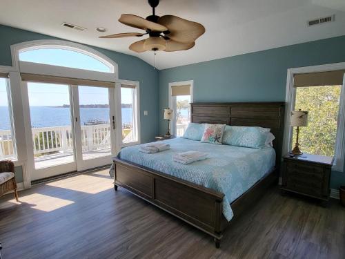 a bedroom with a bed and a ceiling fan at No Fee Luxury Pet Friendly 7BR Soundfront retreat with Elevator, Heated Pool and Hot Tub in Kitty Hawk
