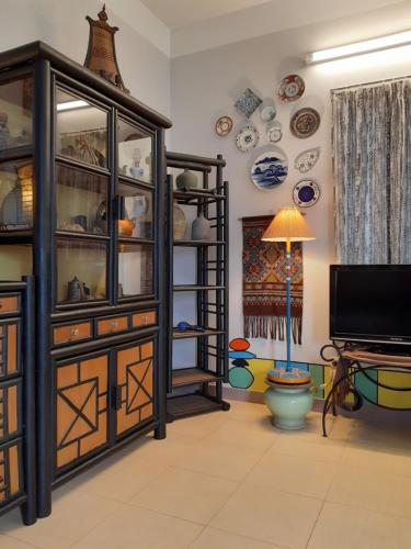 a living room with a hutch and plates on the wall at Tonkin Homestay in Hanoi