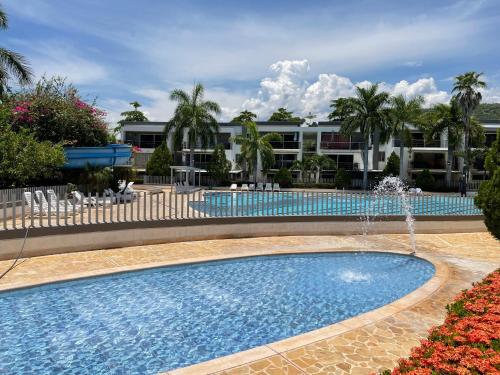 a swimming pool with a fountain in front of a building at Apartasol en Santa Fe de Antioquia in Santa Fe de Antioquia