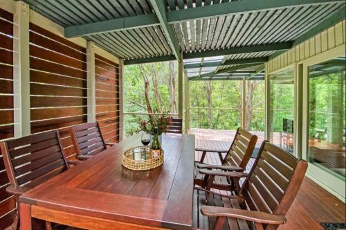 a screened porch with a wooden table and chairs at Mirimvale - Base of Mt Buller - Sleeps 14 in Merrijig