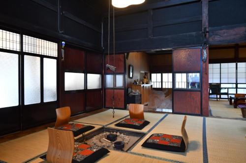 a room with a table and chairs and windows at Togiso 能登の古民家宿 in Togi