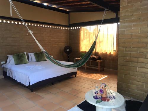 a bedroom with a bed and a hammock in a room at Villas del bambú in San Gil