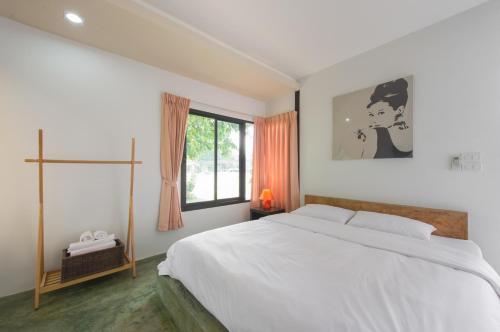 Suptara Resort في ناخون نايوك: غرفة نوم بيضاء مع سرير كبير ونافذة